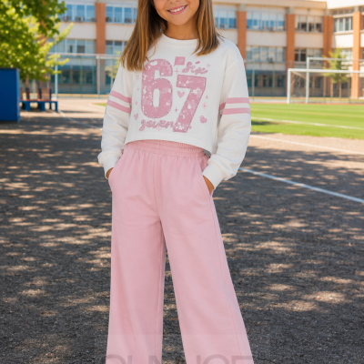 Criança com roupa desportiva rosa e branca num campo exterior