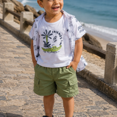 Menino com roupa de verão à beira da praia sorrindo