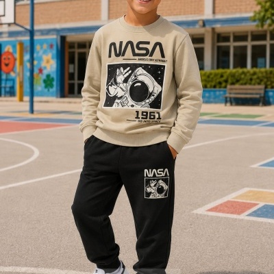 Menino com conjunto NASA bege e preto num campo de basquetebol ao ar livre