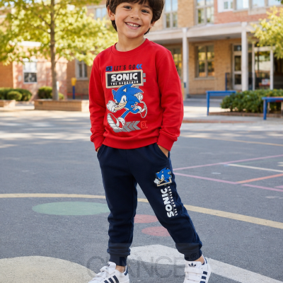 Conjunto infantil de camisola vermelha e calças azuis com estampados do Sonic, com criança sorridente ao ar livre.