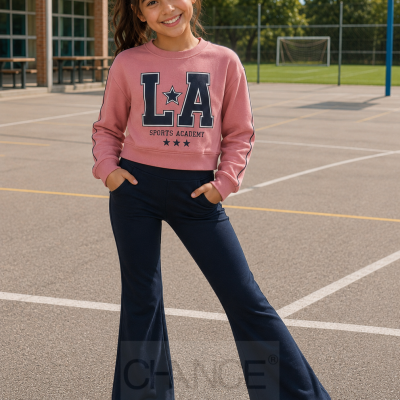 Menina jovem em campo desportivo com sweatshirt rosa e calças azul-escuro