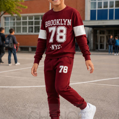 Menino com conjunto bordô e branco com estampado BROOKLYN 78 NYC em ambiente escolar exterior