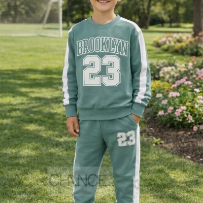 Conjunto infantil verde com estampado Brooklyn 23 e ténis branco e verde ao ar livre num campo