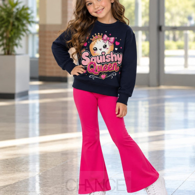 Criança com camisola azul escura com estampa Squishy Queen e calças rosa vibrantes.