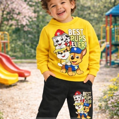 Conjunto infantil amarelo e preto com estampado de cães e texto, criança sorridente num parque infantil.