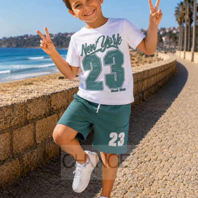 Criança em roupa casual com t-shirt e calções verdes junto ao mar