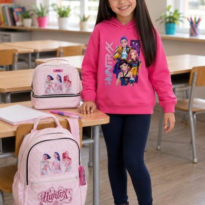 Menina com sweatshirt e mochilas cor-de-rosa com personagens e texto HUNTRIX na sala de aula