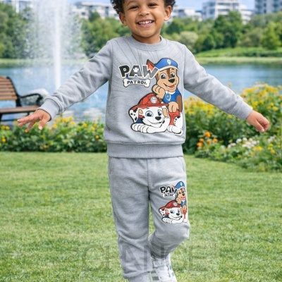 Criança com fato de treino cinzento da PAW PATROL em parque com fonte