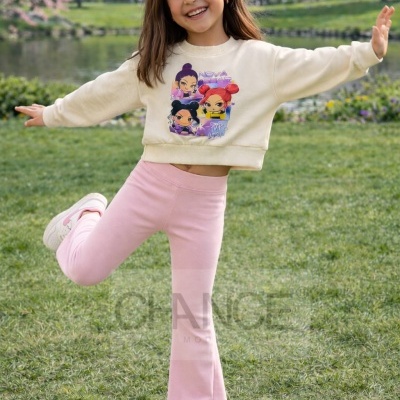 Menina sorridente com camisola estampada creme e calças rosa num parque