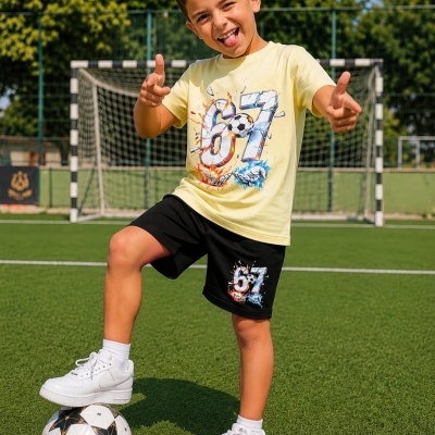 Menino a jogar futebol com roupa desportiva e ténis brancos