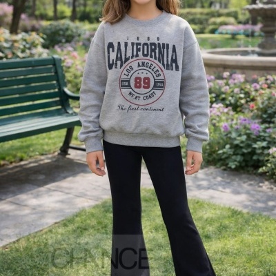 Criança em parque com sweatshirt cinza e calças pretas