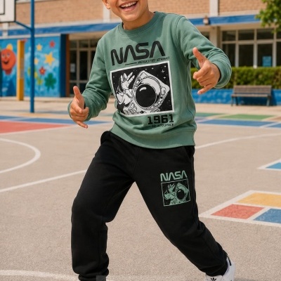 Menino em campo desportivo com roupa NASA verde e preta e ténis brancos