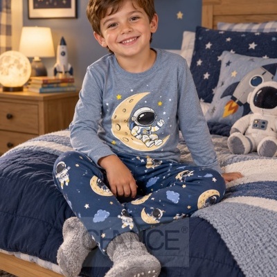 Pijama infantil azul com estampas espaciais usado por criança numa cama temática