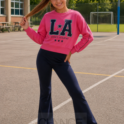 Menina com sweatshirt rosa e calças azul escuro em campo desportivo ao ar livre