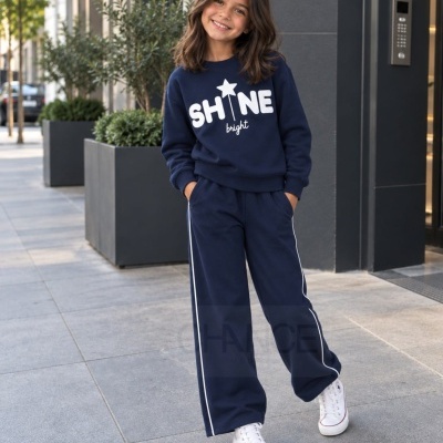 Criança com roupa desportiva azul escuro com texto SHINE bright