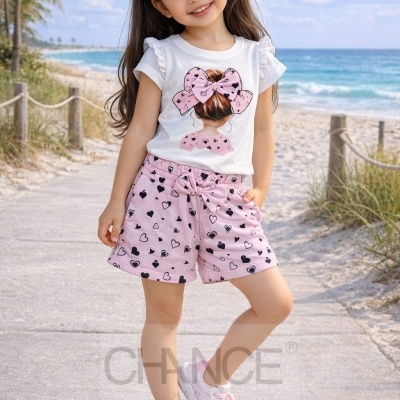 Criança com conjunto de roupa cor-de-rosa e branca com padrão de corações na praia