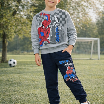 Menino com fato de treino Spiderman num campo de futebol