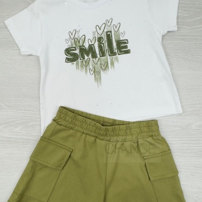 Conjunto infantil de t-shirt branca com estampado verde e calções verdes.
