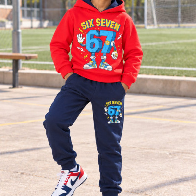Criança com hoodie vermelho e calças azuis com estampado Six Seven num campo de futebol.