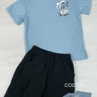 Conjunto infantil com t-shirt azul e calções pretos sobre piso claro