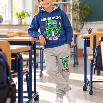 Menino com conjunto de sweatshirt azul e calças cinzentas com estampas Minecraft em sala de aula