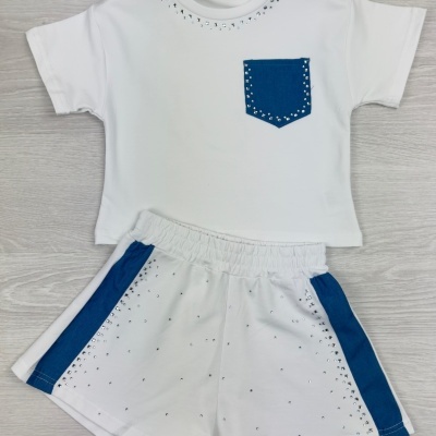 Conjunto infantil branco com bolso azul e brilhantes, calções brancos com riscas azuis e brilhantes.