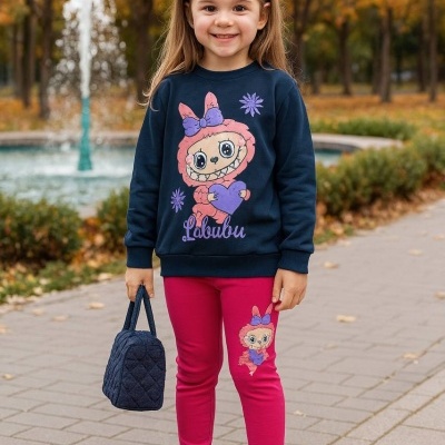 Menina vestindo roupa infantil com personagem animado e faixa na cabeça em parque com fonte e árvores outonais.