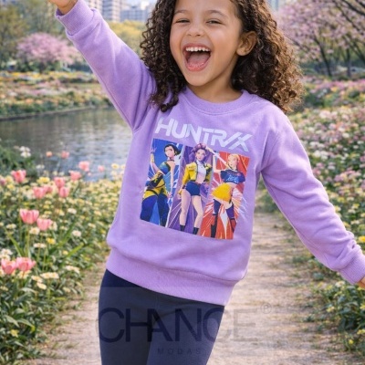 Criança com sweatshirt lilás estampada e leggings azuis escuras num jardim florido.