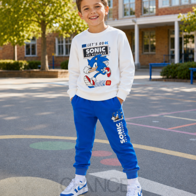 Menino com roupa de algodão com desenho do Sonic, em cenário exterior escolar.