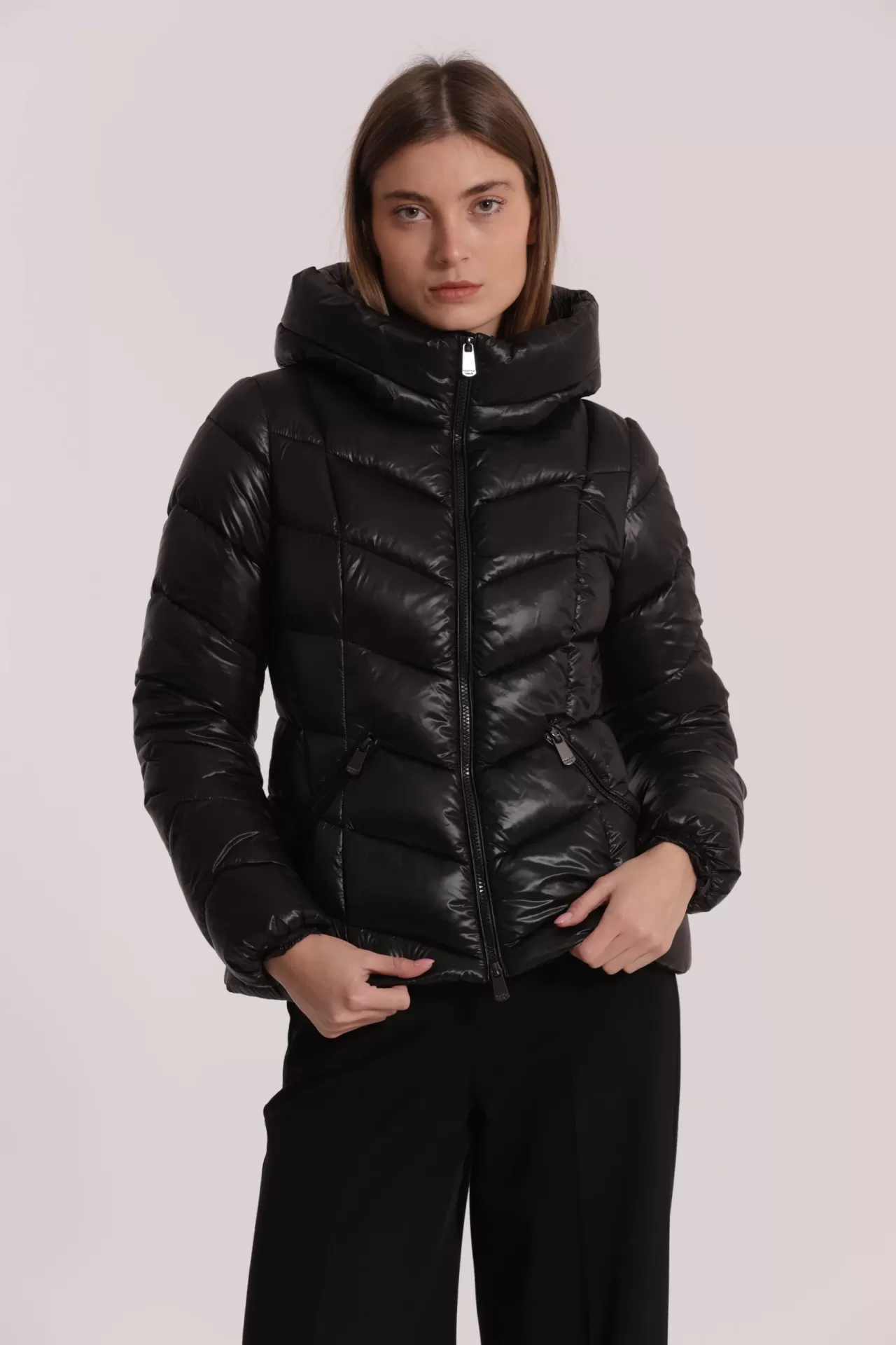 Mulher a usar casaco acolchoado preto com capuz e calças pretas