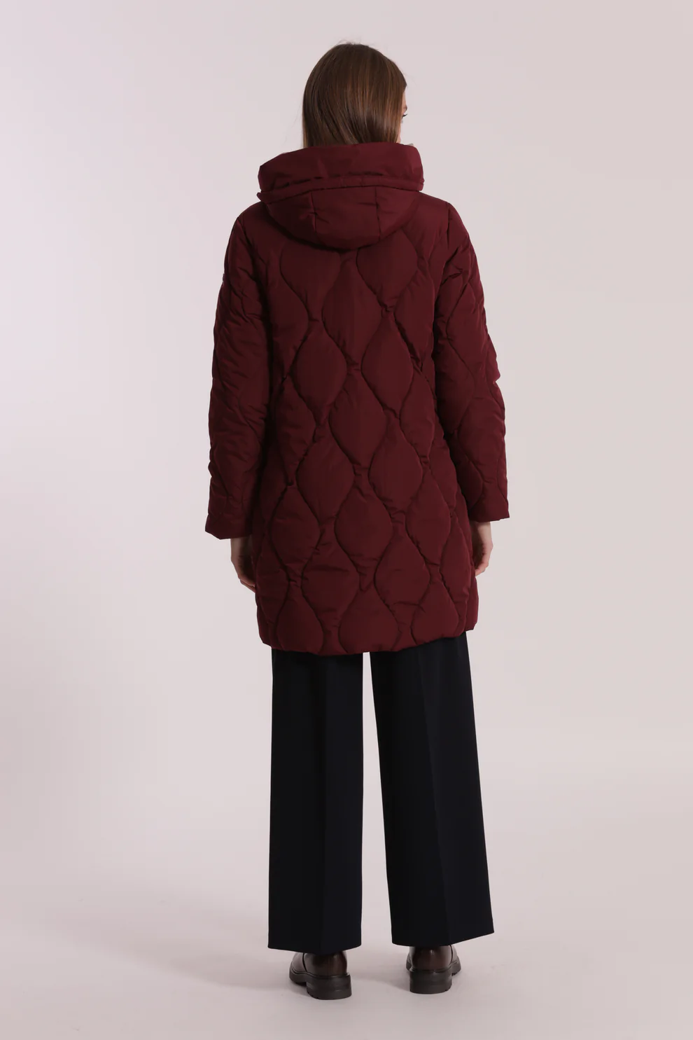 Casaco acolchoado bordeaux com capuz visto de costas.