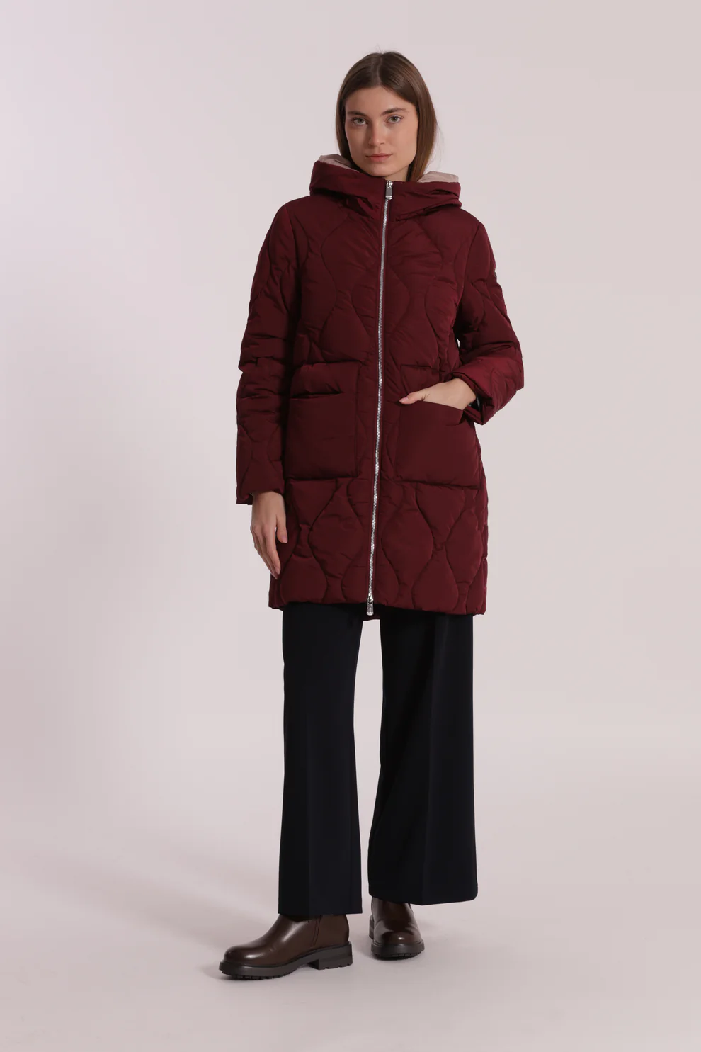 Casaco comprido acolchoado bordô com capuz em fundo neutro
