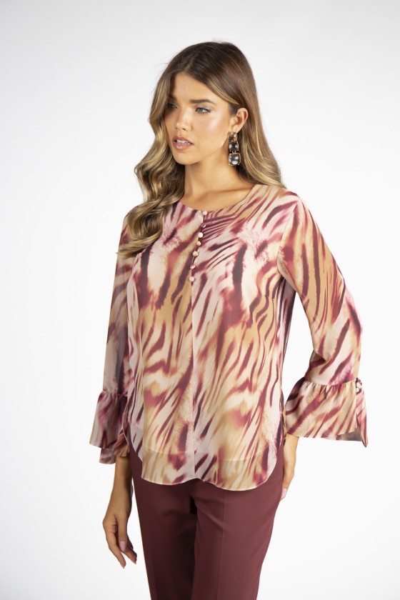 Blusa feminina padrão abstrato bege e vermelho com botões e calças castanhas