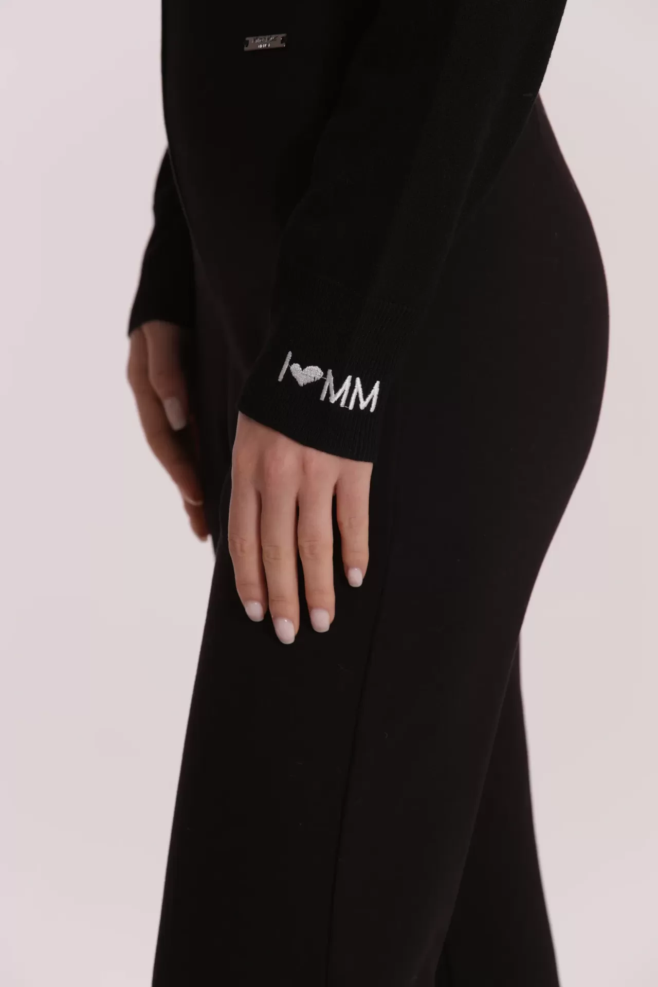 Manga de peça de roupa preta com bordado branco I ♥ MM no punho e etiqueta metálica