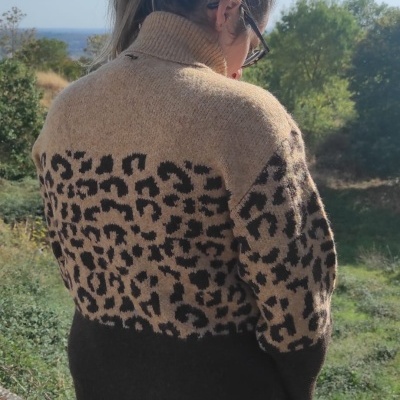 Mulher de costas a usar camisola de malha com estampa animal print e gola alta ao ar livre