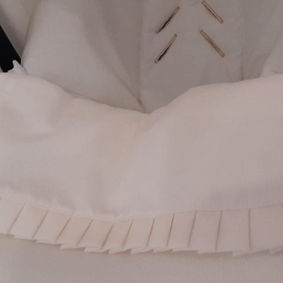 Bolsa branca de tecido com pregas pendurada num cabide branco