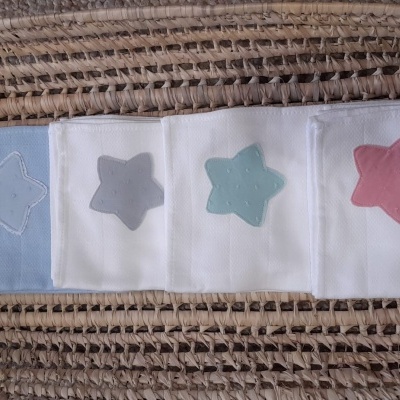 Faixa de tecido com cinco estrelas coloridas sobre esteira trançada castanha