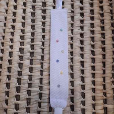 prendedor de chupeta tecido branco com bordados coloridos sobre fibra trançada