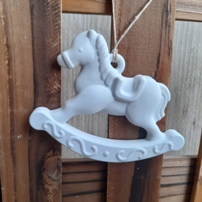 Ornamento em forma de cavalinho de baloiço branco pendurado em madeira