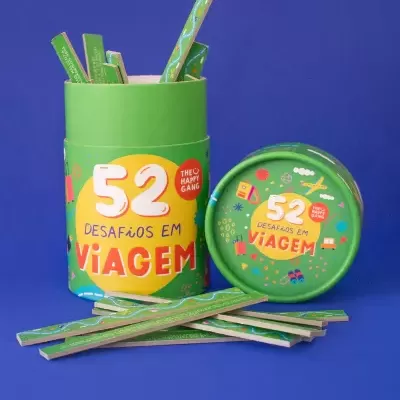 Conjunto de desafios em viagem com embalagem verde e palitos sobre fundo azul