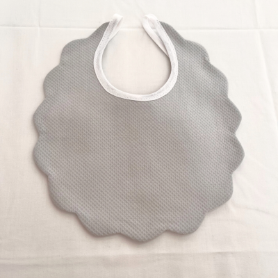 Babete cinzento texturizado com bordas onduladas e fecho branco