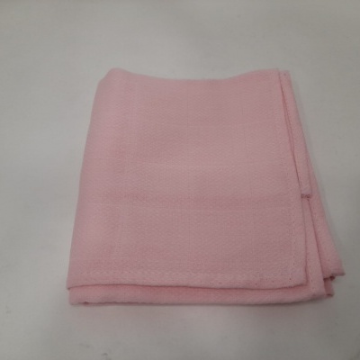 Toalha rosa clara dobrada sobre superfície branca