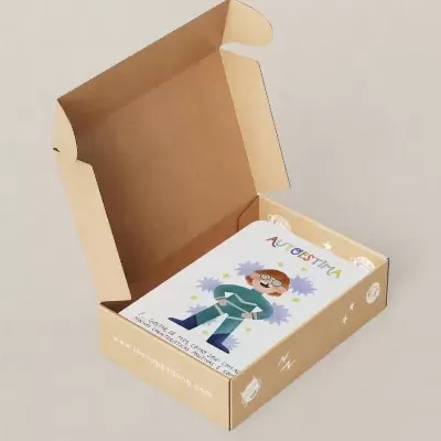 Caixa de cartão aberta com ilustração colorida de criança na tampa e texto AUTOGESTIVA