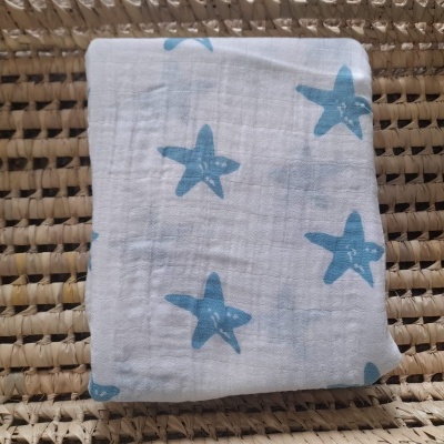 Toalha branca com estrelas azuis sobre superfície de fibras naturais