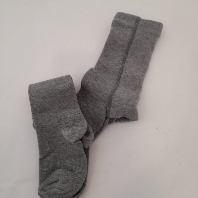 Duas meias cinzentas em tecido malha sobre fundo claro
