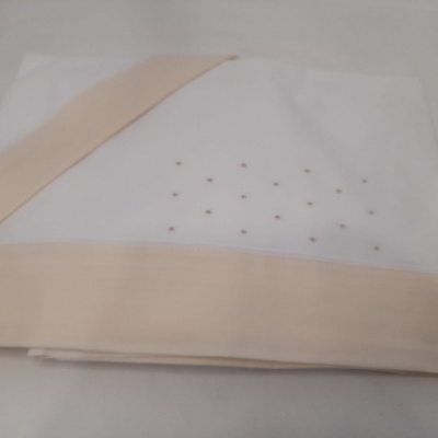 Toalha branca com borda beje e pequenos pontos dourados no centro