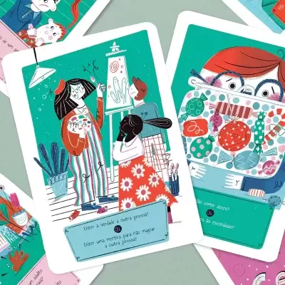 Cartas coloridas com ilustrações e textos em português sobre uma mesa cinza