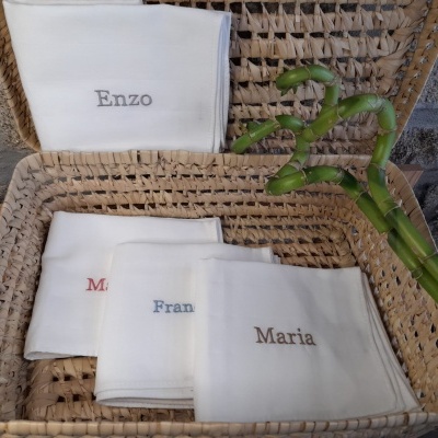 Cesta com toalhas brancas bordadas e bambu