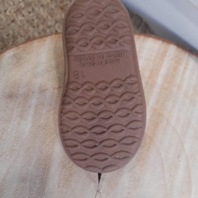 Sola de sapato infantil de borracha castanha com padrão em ondas e texto em relevo