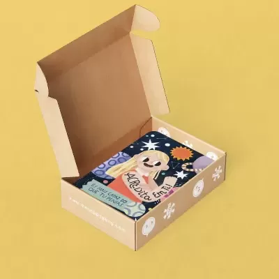 Caixa de cartão aberta com livro ilustrado dentro